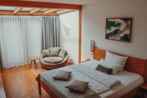 a bedroom with a large bed and a chair at Hotel Gut Hühnerhof in Gründau