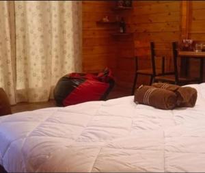 a bedroom with a white bed and a table and chair at wood house vattakanal in Kodaikānāl