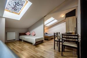 a attic bedroom with two beds and a mirror at Central House in Štúrovo