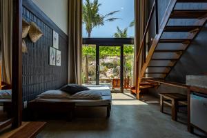 a bedroom with a bed in a room with stairs at Rock Bay by Chành Rành in Vĩnh Hy
