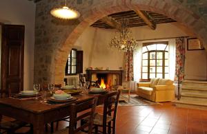 a living room with a table and a fireplace at Pieve di Caminino Historic Farm in Podere Caminino