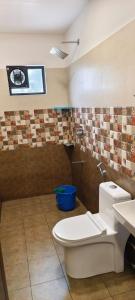 a bathroom with a toilet and a sink at Green Lounge in Munnar