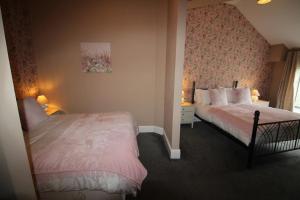 a bedroom with two beds and a window at Cornerhouse Apartments 3 Sleeps 7 in Llandudno