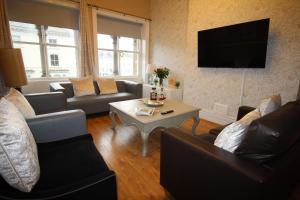 a living room with couches and a coffee table at Cornerhouse Apartments 3 Sleeps 7 in Llandudno
