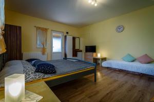 a bedroom with two beds and a clock on the wall at Ubytovanie Bonita in Štúrovo