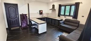 a kitchen with a counter and a couch in a room at Green Lounge in Munnar