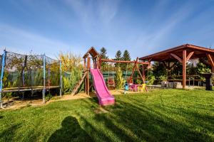 een speeltuin met een roze glijbaan in het gras bij Ubytovanie Bonita in Štúrovo