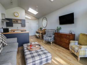 a living room with a couch and a table at Doe Lodge in Rhayader