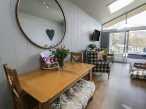 a dining room with a table and a mirror at Doe Lodge in Rhayader