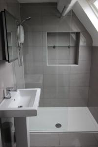a bathroom with a sink and a shower at Cornerhouse Apartments 4 Sleeps 5 in Llandudno