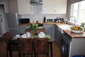 a kitchen with a table with a bowl of fruit at Cornerhouse Apartments 4 Sleeps 5 in Llandudno +12 photos