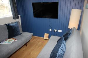 a living room with a couch and a flat screen tv at Cornerhouse Apartments 4 Sleeps 5 in Llandudno