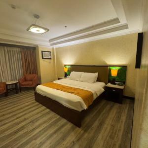 a hotel room with a large bed and a chair at MO2 Westown Hotel - Mandalagan in Bacolod +29 photos