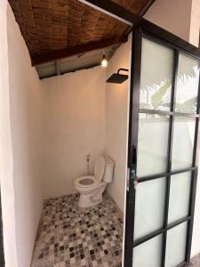 a bathroom with a toilet and a glass door at Mias Home in Sunggal +19 photos