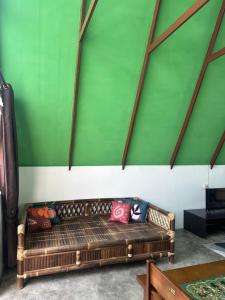 a brown couch in a room with a green wall at Mias Home in Sunggal