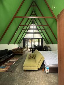 a bedroom with a large bed and a green ceiling at Mias Home in Sunggal