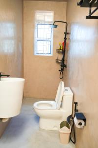 a bathroom with a toilet and a window at Cosy Homes in Gulu +18 photos