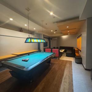 a living room with a pool table and a light at MO2 Westown Hotel - Mandalagan in Bacolod