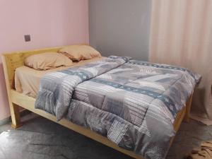 a bed with a wooden frame in a bedroom at Cosy Homes in Gulu