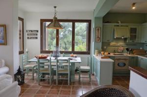 a kitchen with a table and chairs in a room at Centaur Suites & Maisonettes in Miléai