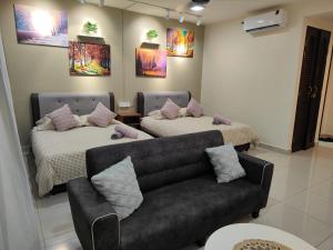 a living room with two beds and a couch at Trefoil Studio Unit Near Setia City Mall 1-5 Pax in Shah Alam