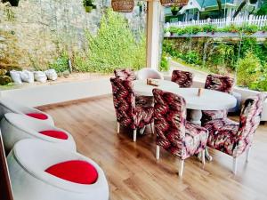 a dining room with a white table and chairs at Clover Cottage in Nuwara Eliya