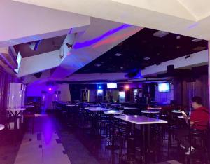a room with tables and chairs and purple lights at MO2 Westown Hotel - Mandalagan in Bacolod