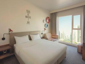 a hotel room with a bed and a window at Rove Downtown in Dubai