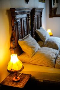 a bed with two pillows and a lamp on a table at Antik Porta-Hangulatos parasztház kerttel,borospincével és infraszaunával in Szakony