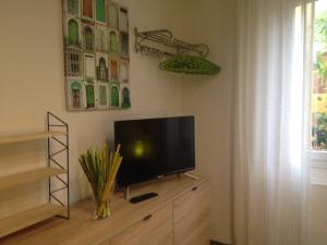 een flatscreen-tv op een dressoir bij Decorialab Apartments in Bologna