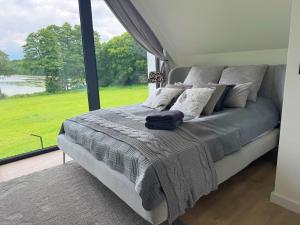 a bed in a room with a large window at Ostoja Dębowa Studnica in Studnica