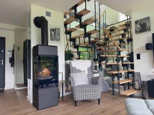a living room with a fireplace and a spiral staircase at Ostoja Dębowa Studnica in Studnica