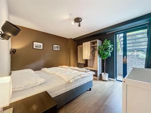 a bedroom with a large bed and a window at DURBUY au "trois marcassins" in Durbuy +28 photos