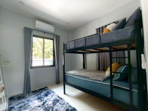 a bedroom with two bunk beds and a window at Tanner House Krabi in Ban Klang