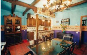 uma cozinha com paredes roxas e uma mesa e cadeiras em Marqueño Turismo Rural em Vianos