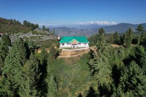 a house on a hill with a green roof at Forest rest house Tannu Jubbar - Ecotourism in Kanethi