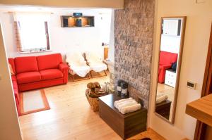 a living room with a red couch and a fireplace at Cottage House Jakob in Cerklje na Gorenjskem