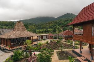 a group of houses with mountains in the background at Munduk Seming Cottages in Munduk