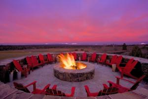 Brasada Ranch في Powell Butte: مجموعة من الكراسي الحمراء جالسين حول حفرة النار