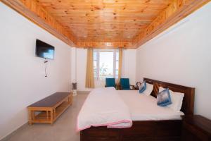 a bedroom with a large bed with a wooden ceiling at Forest rest house Tannu Jubbar - Ecotourism in Kanethi
