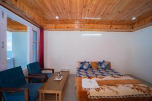 a bedroom with a bed and a table and chairs at Forest rest house Tannu Jubbar - Ecotourism in Kanethi