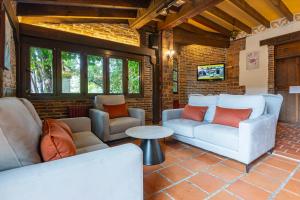 a living room with two couches and a table at Conjunto Hotelero La Pasera in Soto de Cangas
