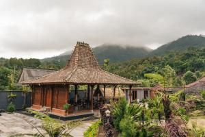 a small hut with a roof on a mountain at Munduk Seming Cottages in Munduk