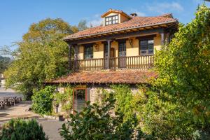 an old house with a balcony on top of it at Conjunto Hotelero La Pasera in Soto de Cangas