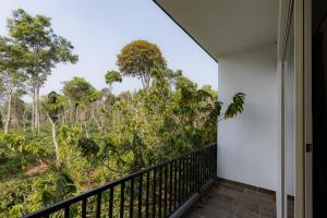 a balcony with a view of the forest at Bougain Villa in Madikeri