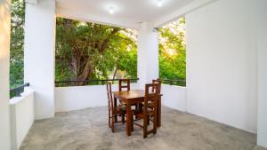 a table and two chairs on a balcony with trees at OKI Nature Resort in Dambulla