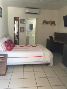 1 dormitorio con cama, escritorio y piano en Black Marlin Motel en Innisfail