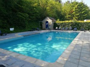 a swimming pool with blue water in a yard at DURBUY au "trois marcassins" in Durbuy
