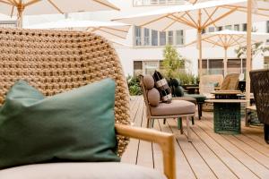 a patio with chairs and umbrellas on a deck at Motel One München-Haidhausen in Munich +21 photos