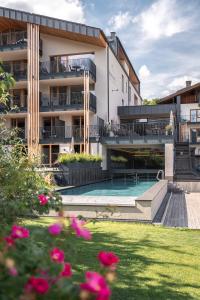 a hotel with a swimming pool and a building at Maraias - Luxury Suites & Apartments in Burgusio